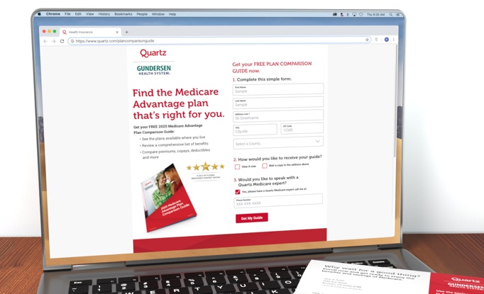 Macbook on a wooden table showing a Quartz landing page for a free plan comparison guide with information five star Medicare Advantage plans