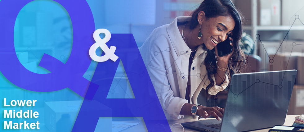 Professional business woman in white blazer smiling while talking on phone and working on laptop, with 'Q&A Lower Middle Market' text overlay on blue geometric background with data visualization elements.
